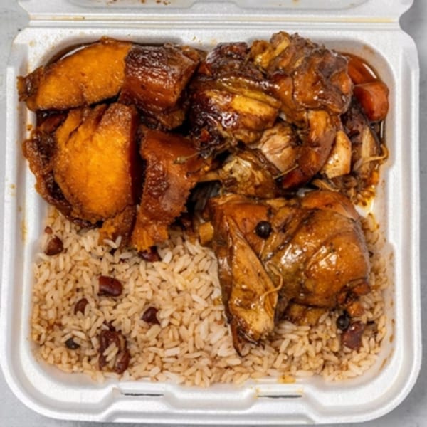 A takeout container filled with Jamaican brown stew chicken and rice and peas.